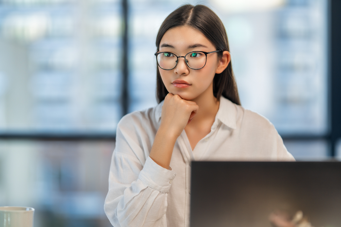 A Filipina applicant in glasses looking focused while attending a virtual interview.