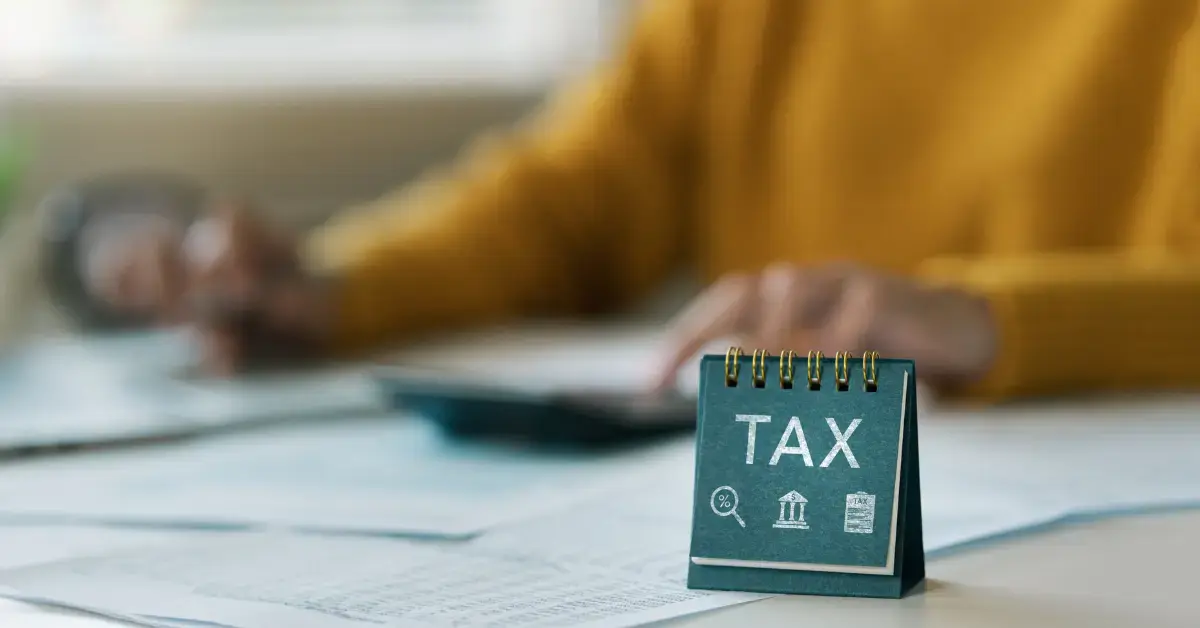 Woman reviewing instructions for Form 7004 on a laptop, preparing tax documents.