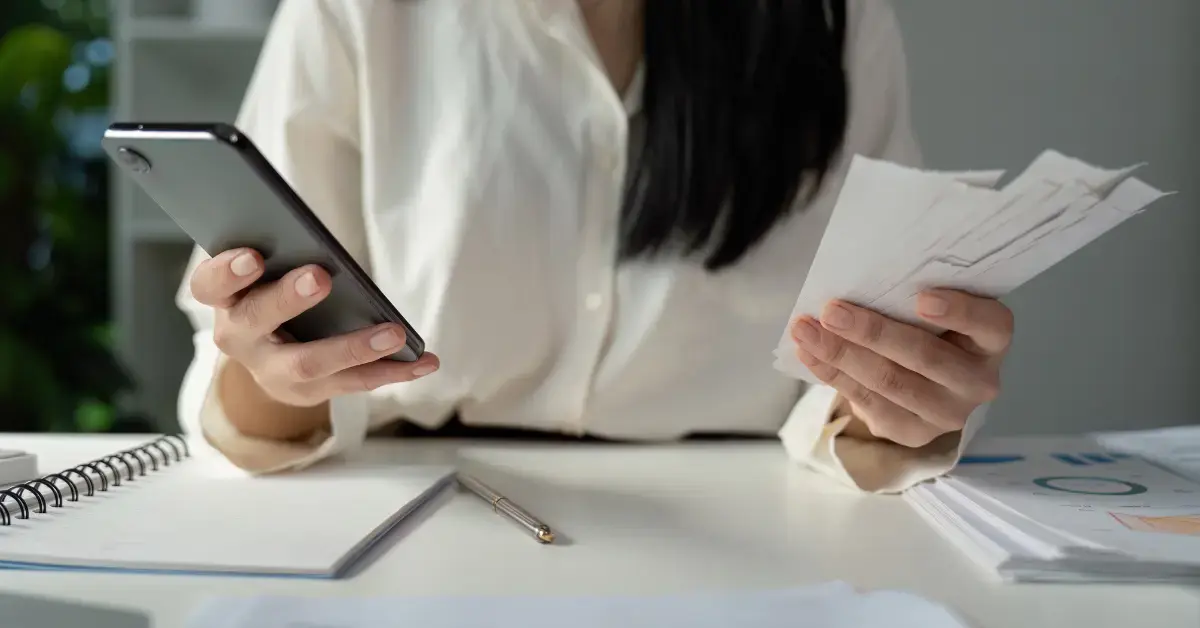 Woman reviewing financial records and bank statements while learning about bookkeeping clean-up services.