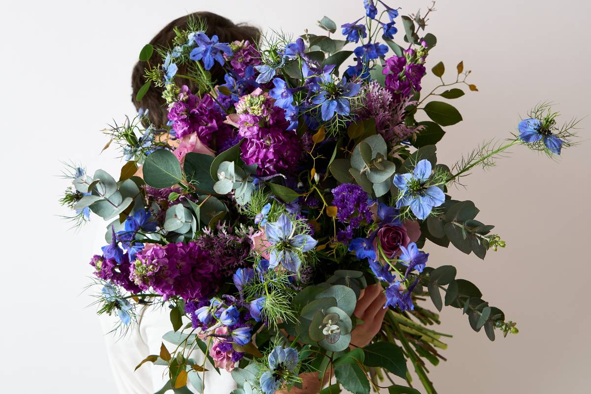 Gift delivery Cape Town of a blue and purple flower bouquet held by local florists, personalized customer service with beautiful flowers