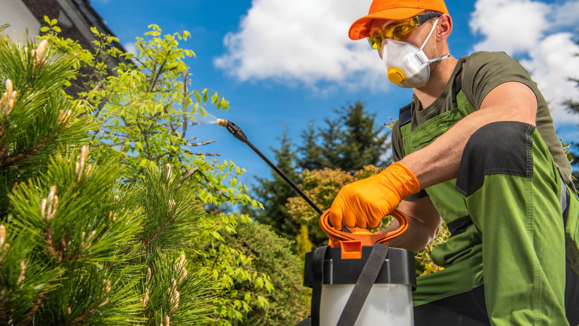 A person using protective equipment while using a mosquito killer spray.