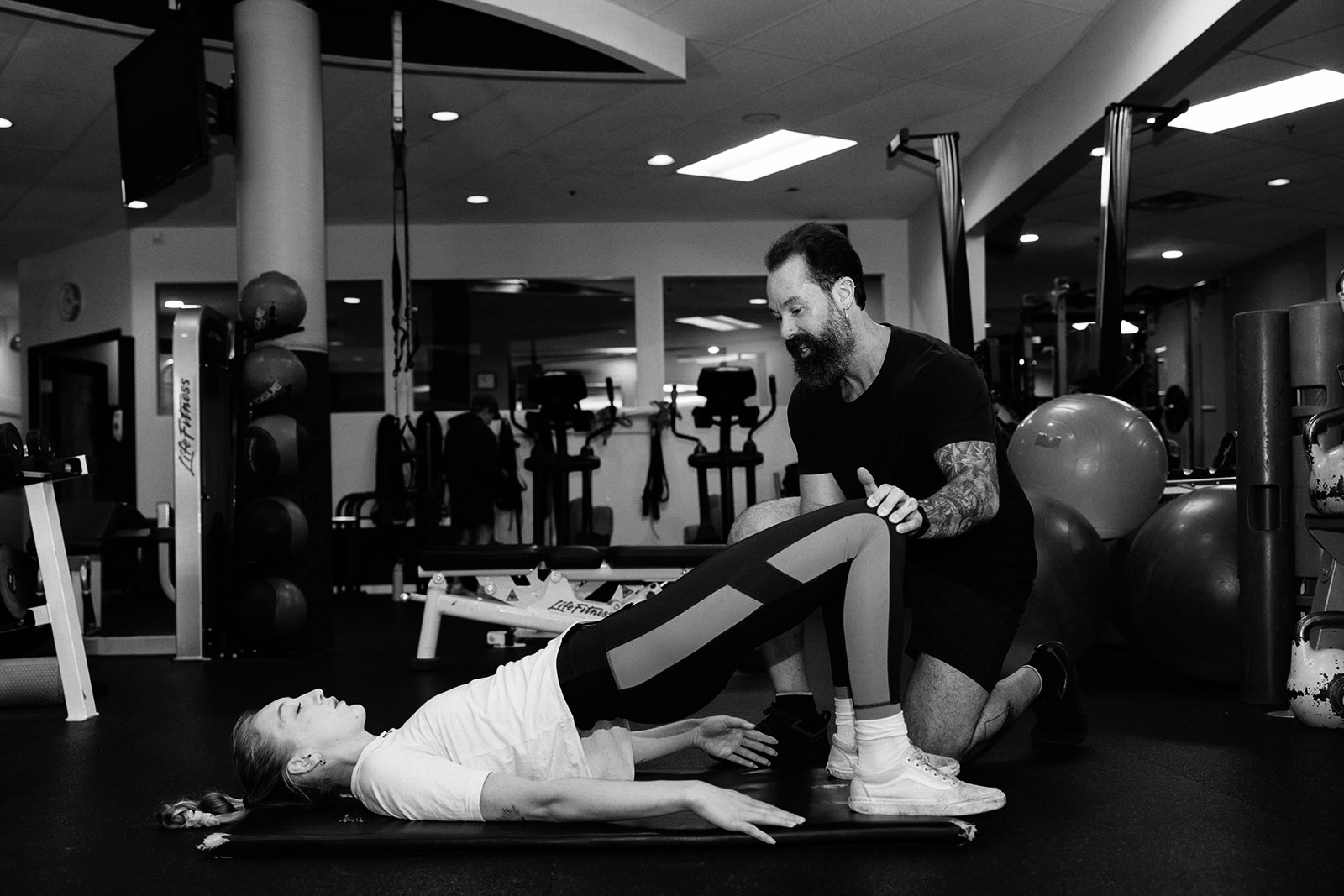 A personal trainer helping a client with a personal training session