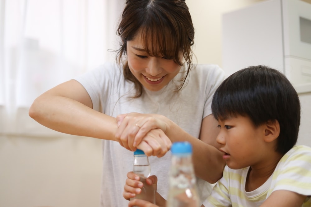 Parents and children dropping marbles from ramune bottles