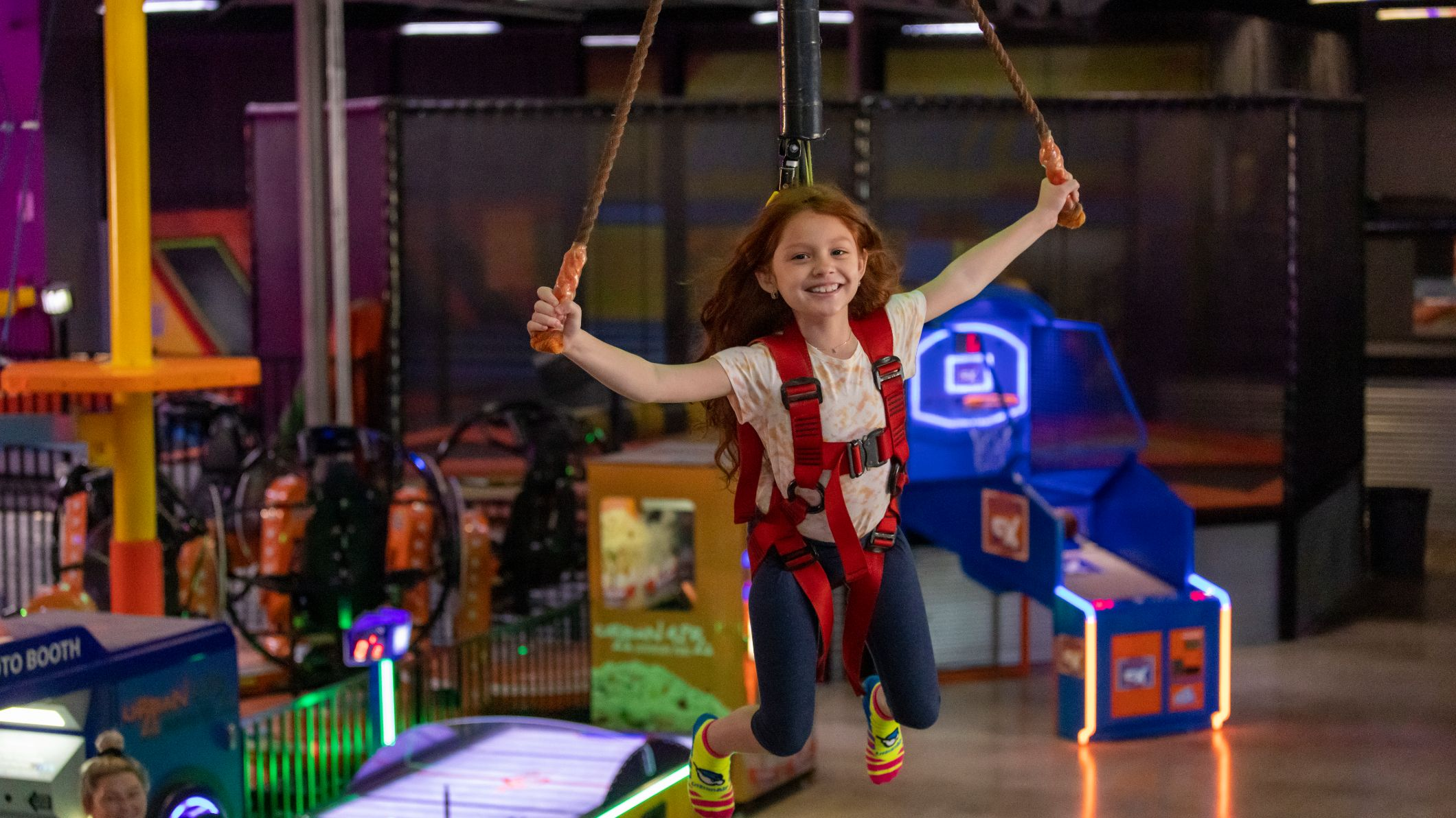 A 7-year-old girl enjoys the Sky Rider Indoor Zipline attraction at Urban Air