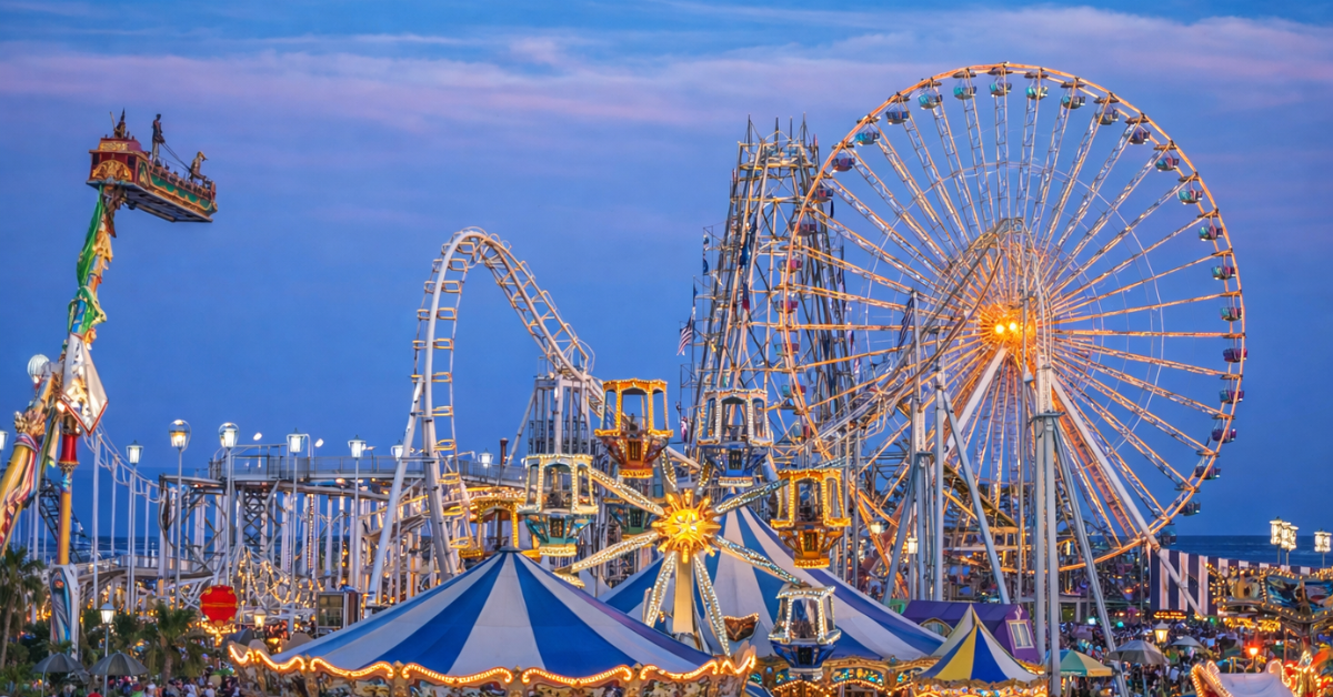 Wildwood boardwalk amusement park with Ferris wheel, roller coasters, and rides lit up at dusk along the Jersey Shore in Wildwood New Jersey.