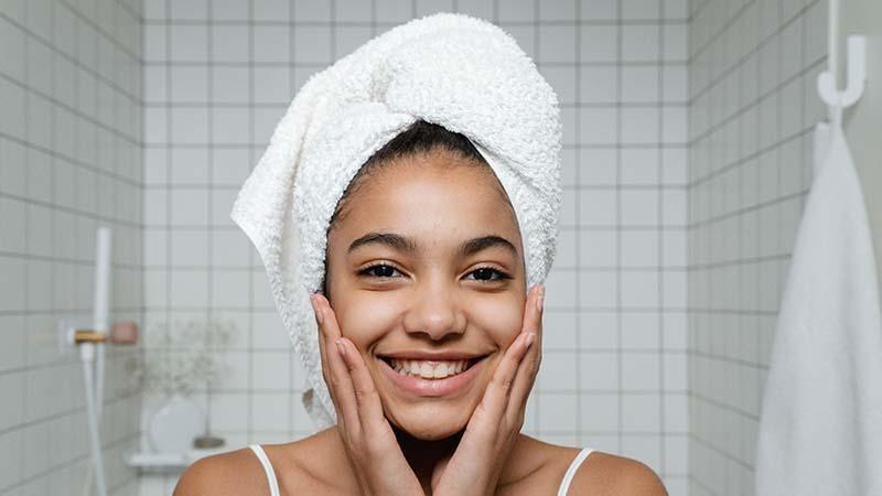 A woman with her head wrapped in a towel