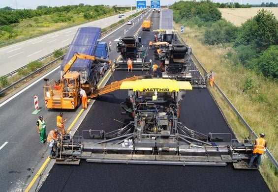 A photo of a paver screed and a floating screed being used to prevent future cracking on a hot mix asphalt surface