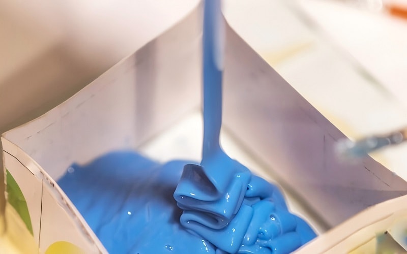 pouring silicone into a mold for casting
