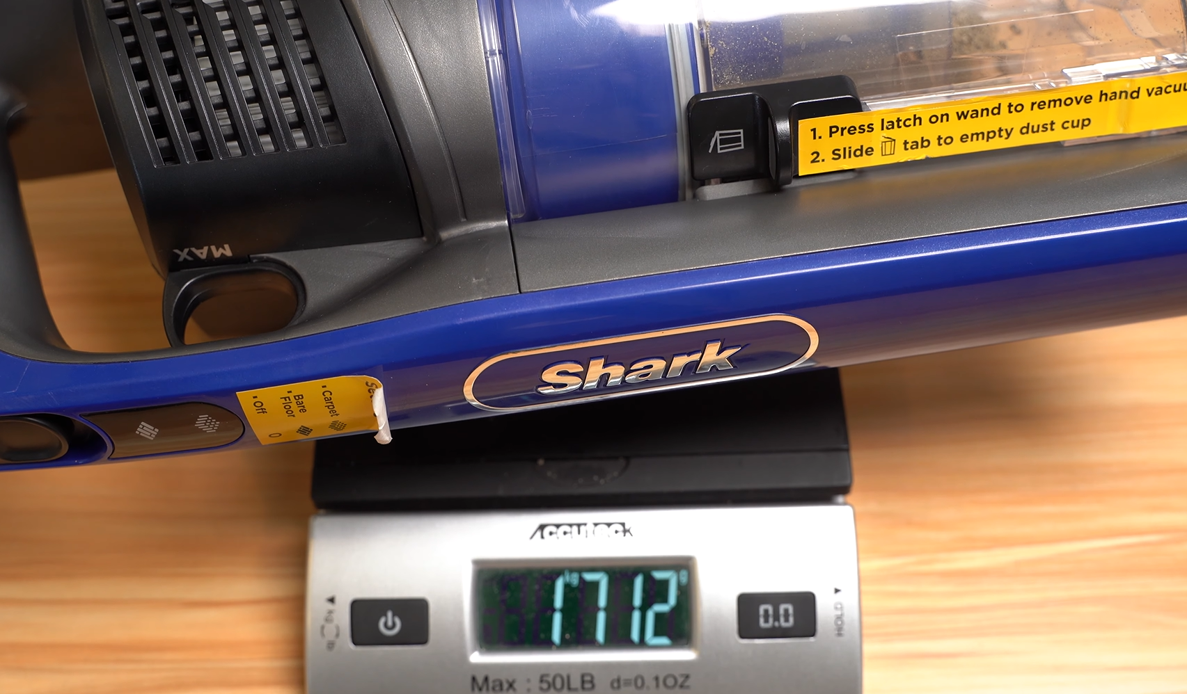 Shark iz340h being weighed after collecting sand from carpet