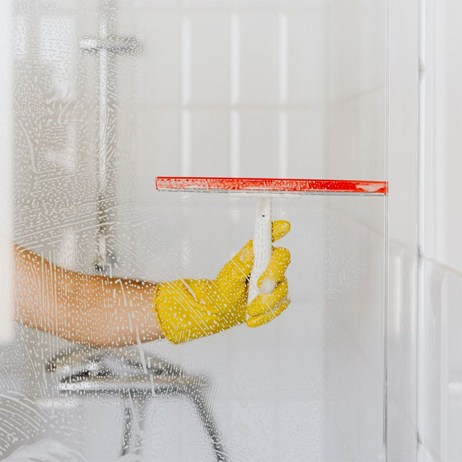 Clean the glass shower screen with a squeegee