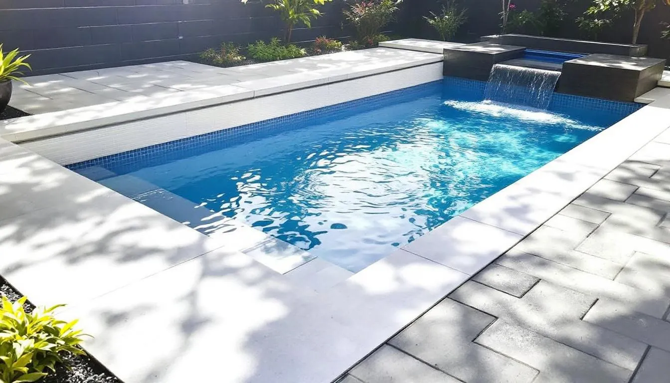 A beautifully remodeled swimming pool showcases a smooth, resurfaced surface and elegant waterline tile, enhancing the aesthetic appeal of the backyard space. This pool renovation project highlights luxury elements like LED lighting