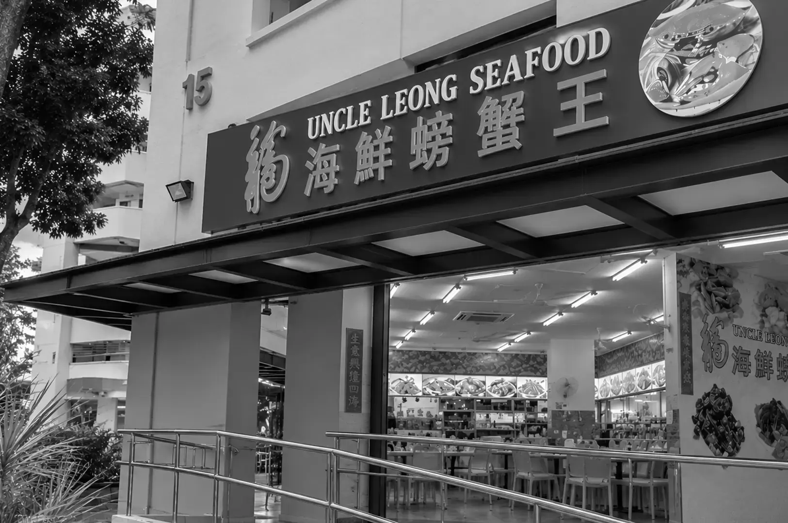Exterior view of Uncle Leong Seafood restaurant featuring its large signboard, open entrance, bright interior lighting, and rows of dining tables and chairs.