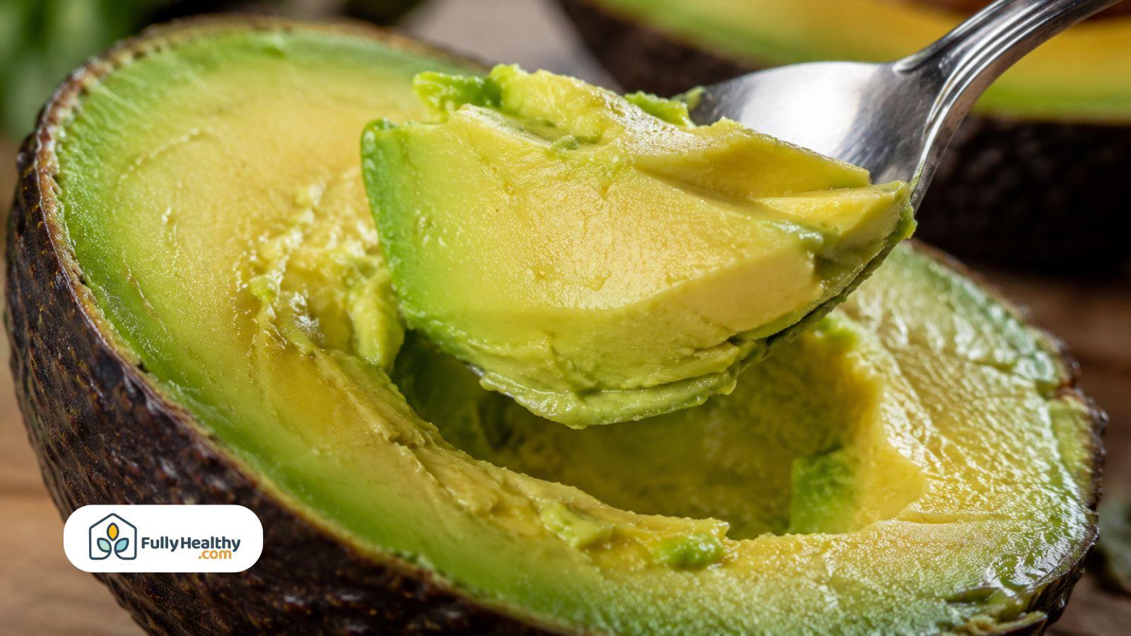 Close-up of ripe avocado texture being scooped with a spoon.