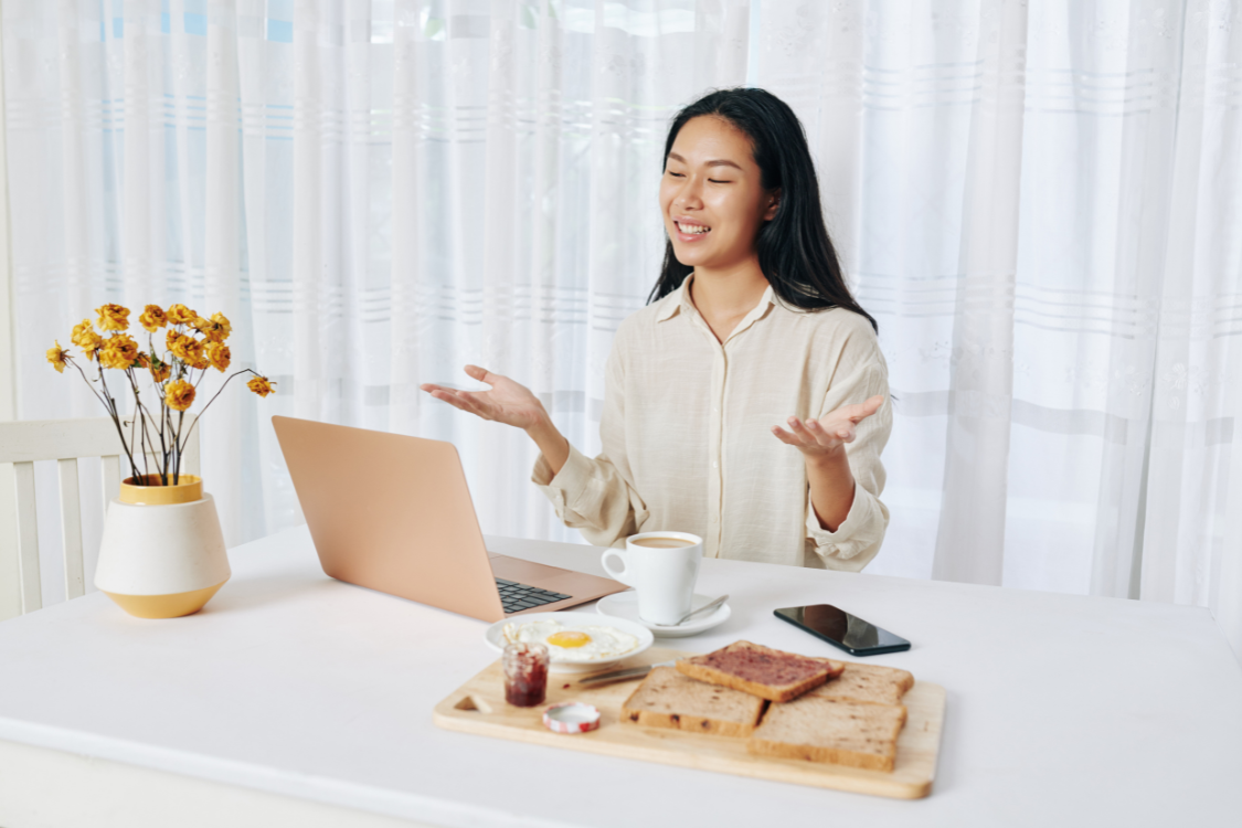 A Filipino remote worker enjoying breakfast during a relaxed video call