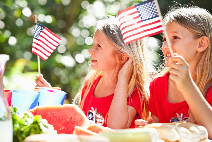 Two little girls waving American flags. 