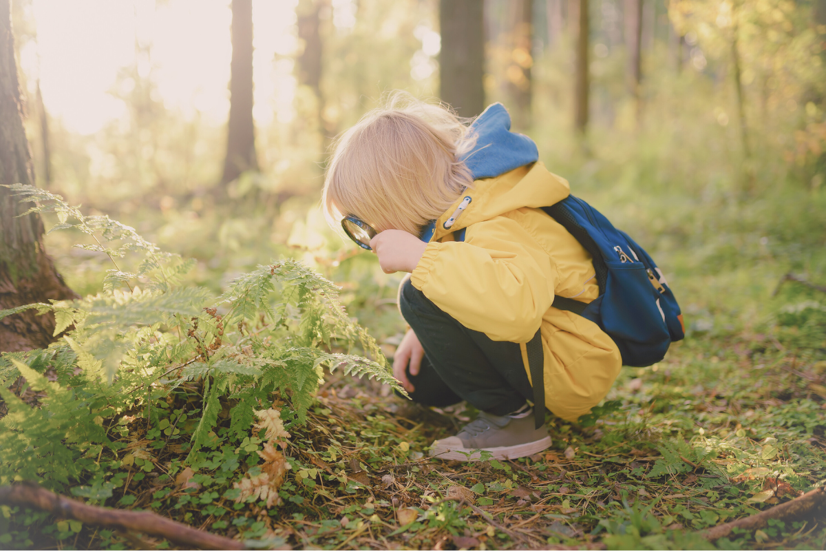 Child exploring with a magnifying glass