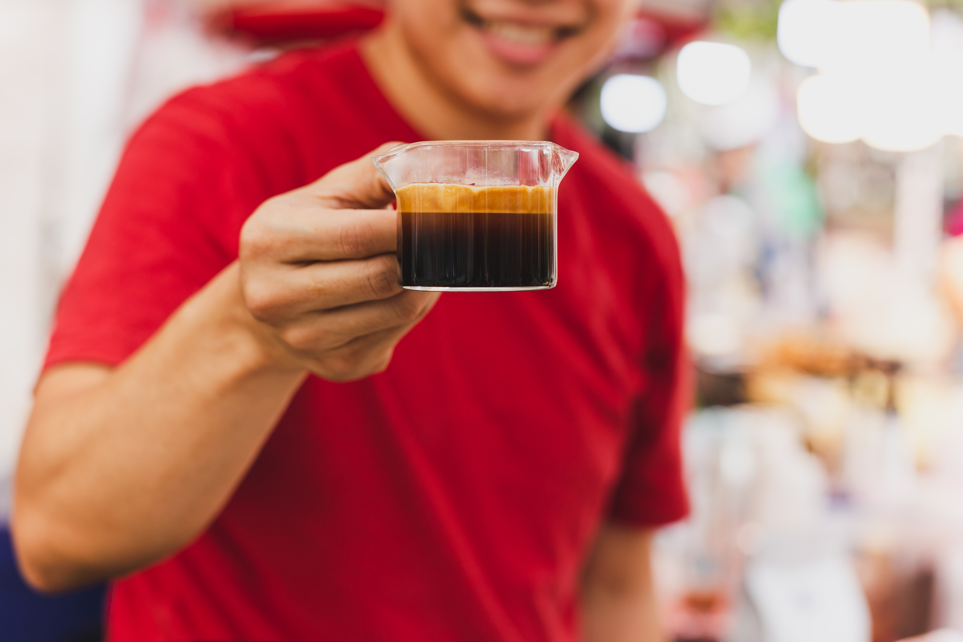 person holding a glass of espresso shot