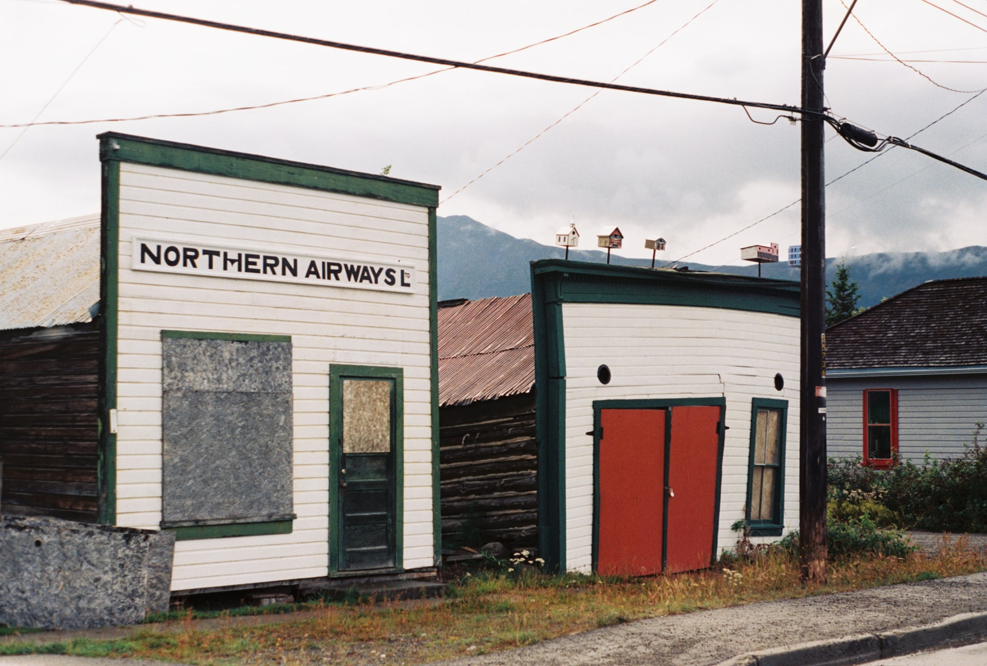 A building with a red door on the side of a road at Carcross in Yukon.