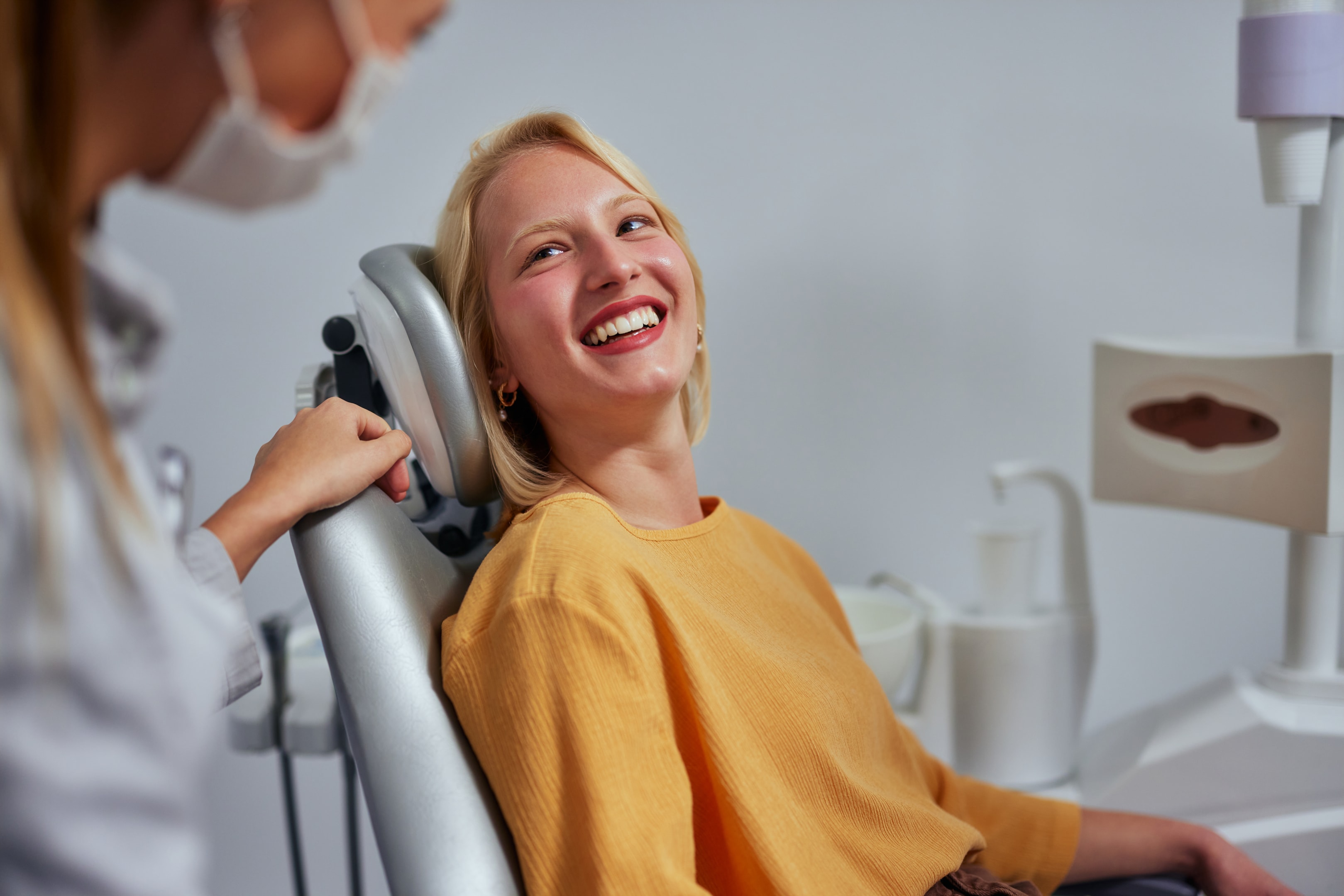 Woman sitting in patient chair getting treatment for her submucous cleft palate 