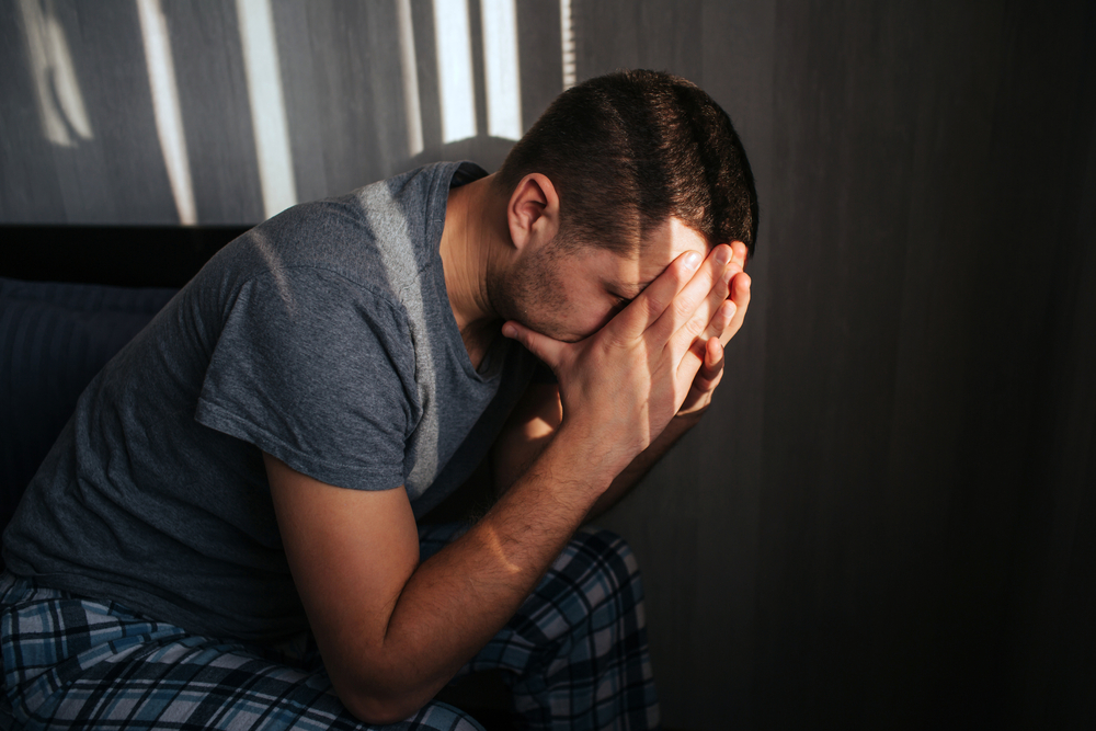 A man with his head in his hands, clearly worried about something. 