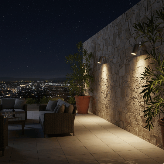 Outdoor spot lights mounted on a stone wall, illuminating a stylish patio area with a view of the city skyline at night.