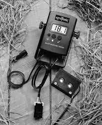 A hay moisture tester with a calibration clip attached to the probe