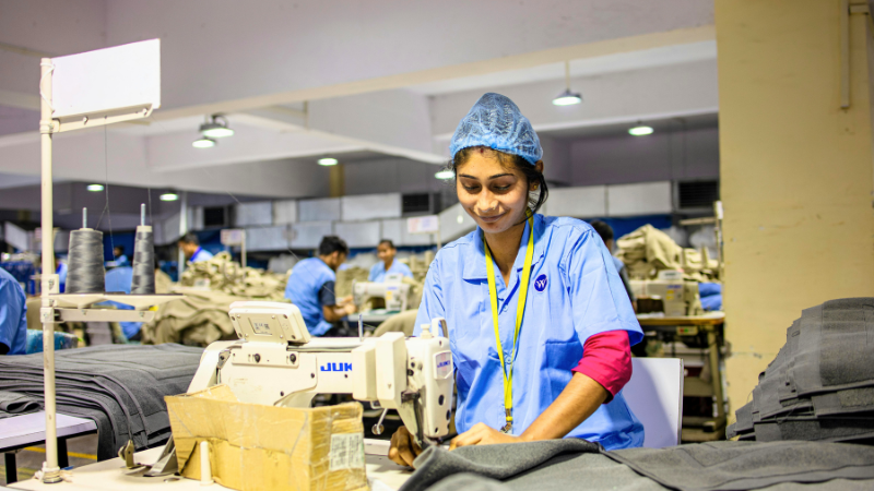 A person working on a sewing machine in a factory