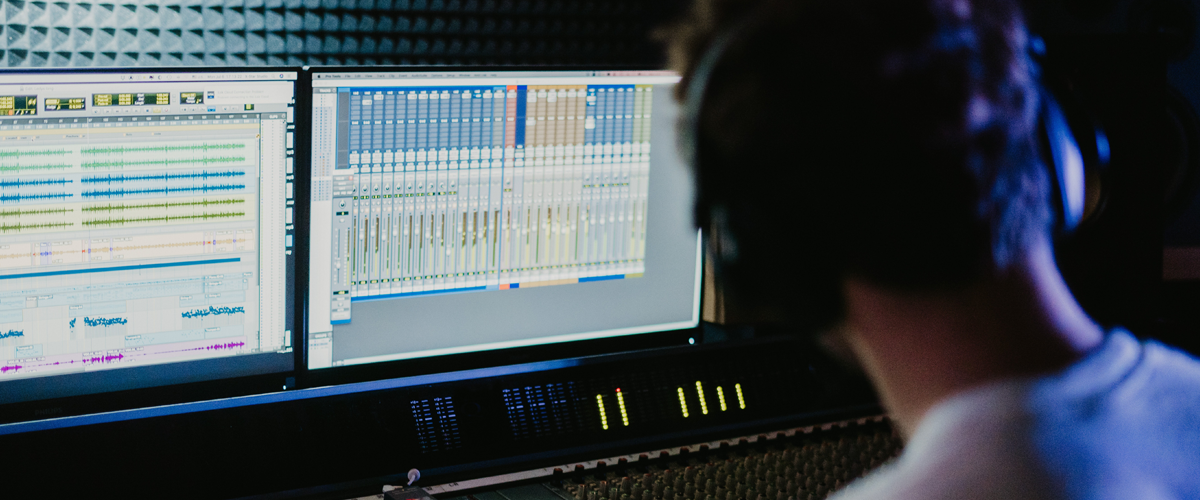 A sound engineer mixing at a digital audio workstation (DAW)