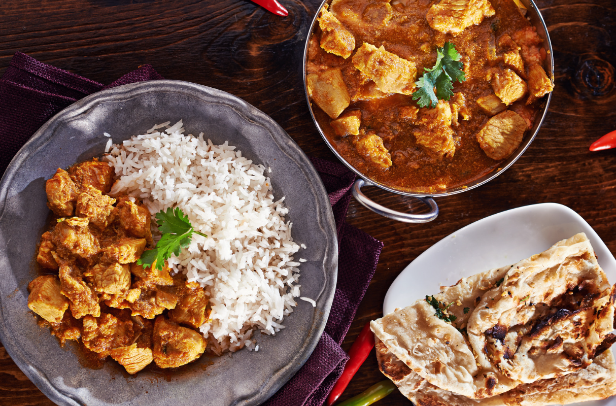 Plates with curry, rice and naan bread
