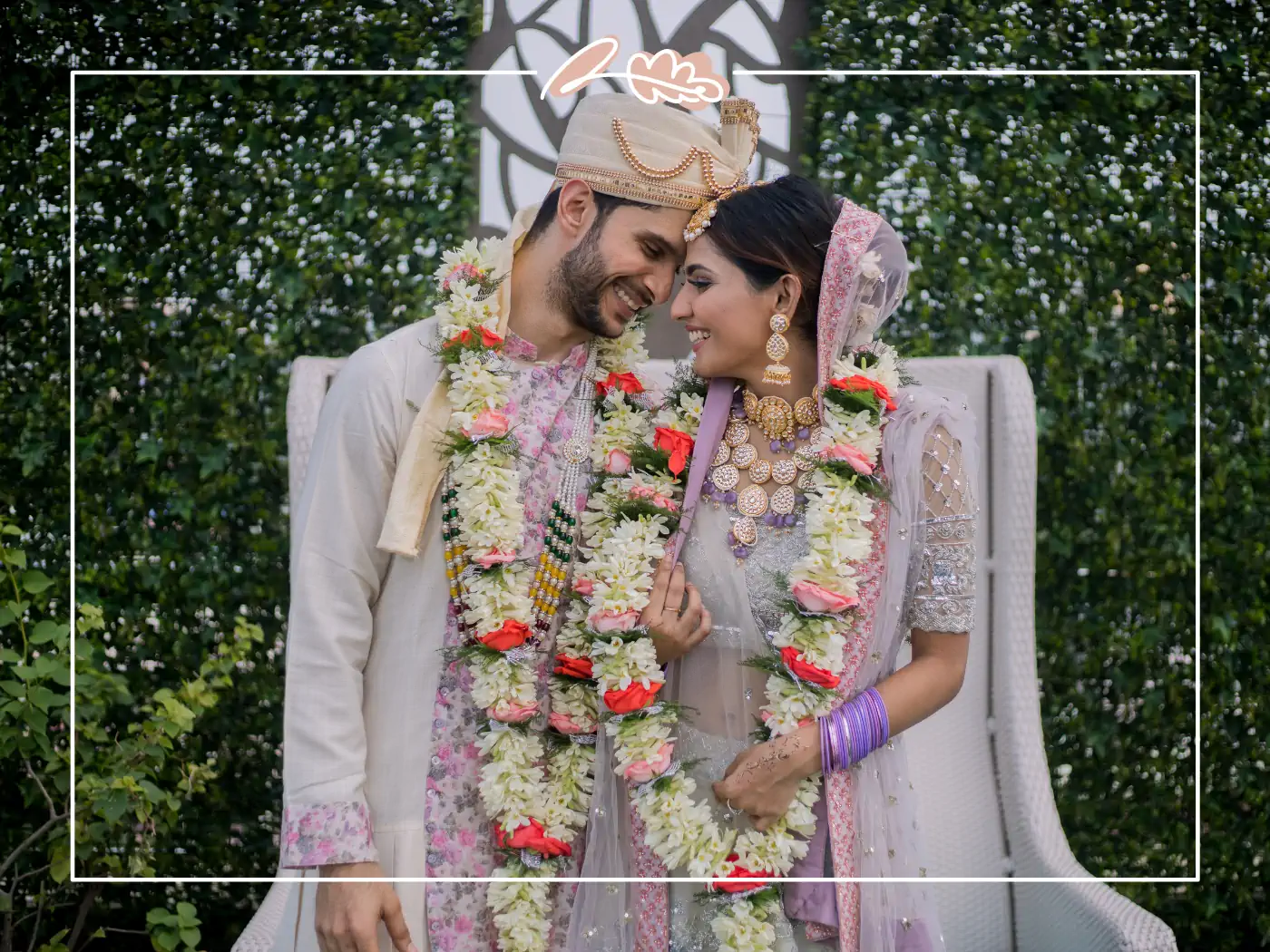 Joyful Indian bride and groom adorned with floral garlands, smiling and leaning into each other. Fabulous Flowers & Gifts