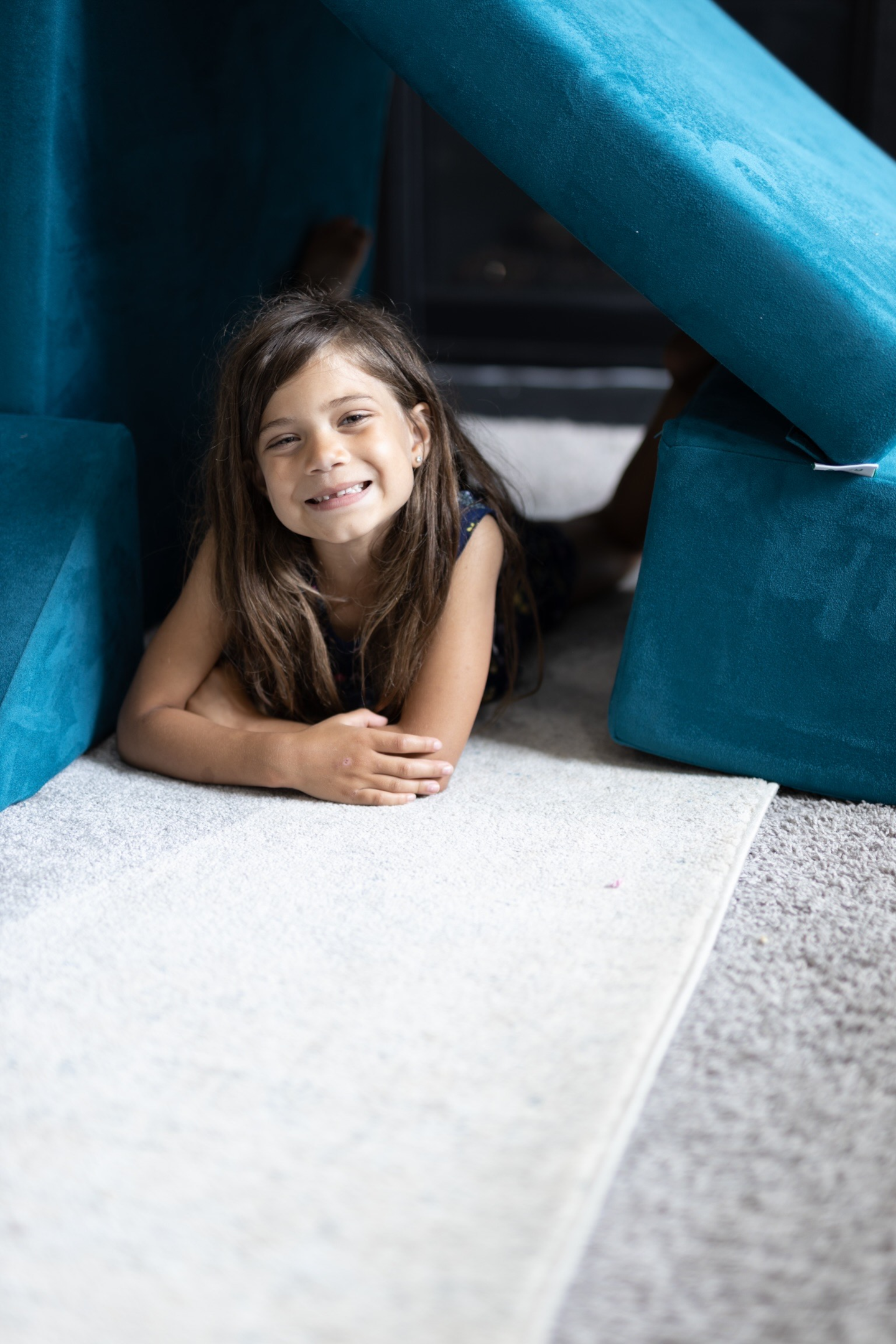 Children engaged in imaginative play on a play couch