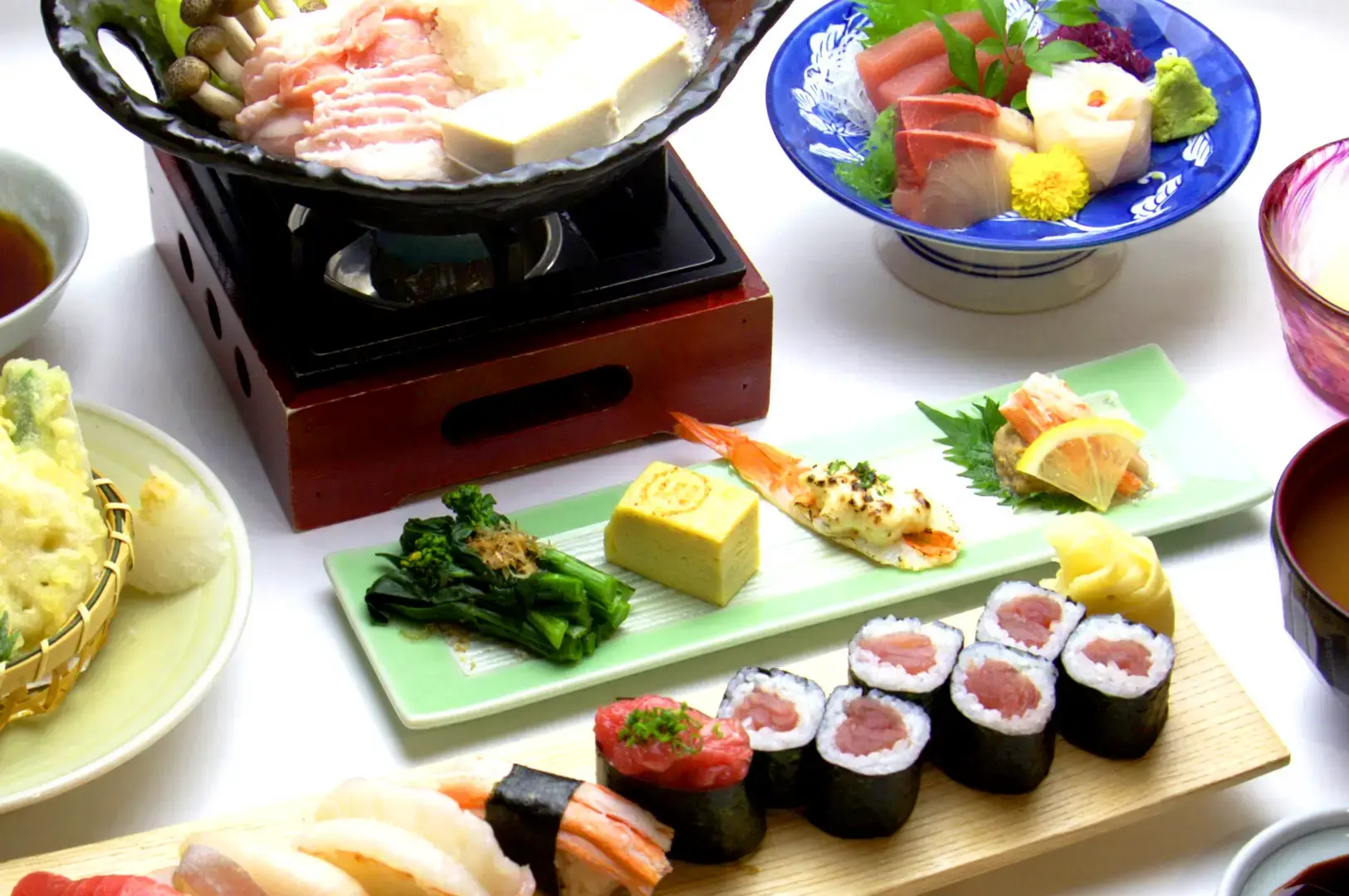 Tomi Sushi Singapore Japanese meal featuring sushi rolls, sashimi, grilled seafood, vegetables and hot pot