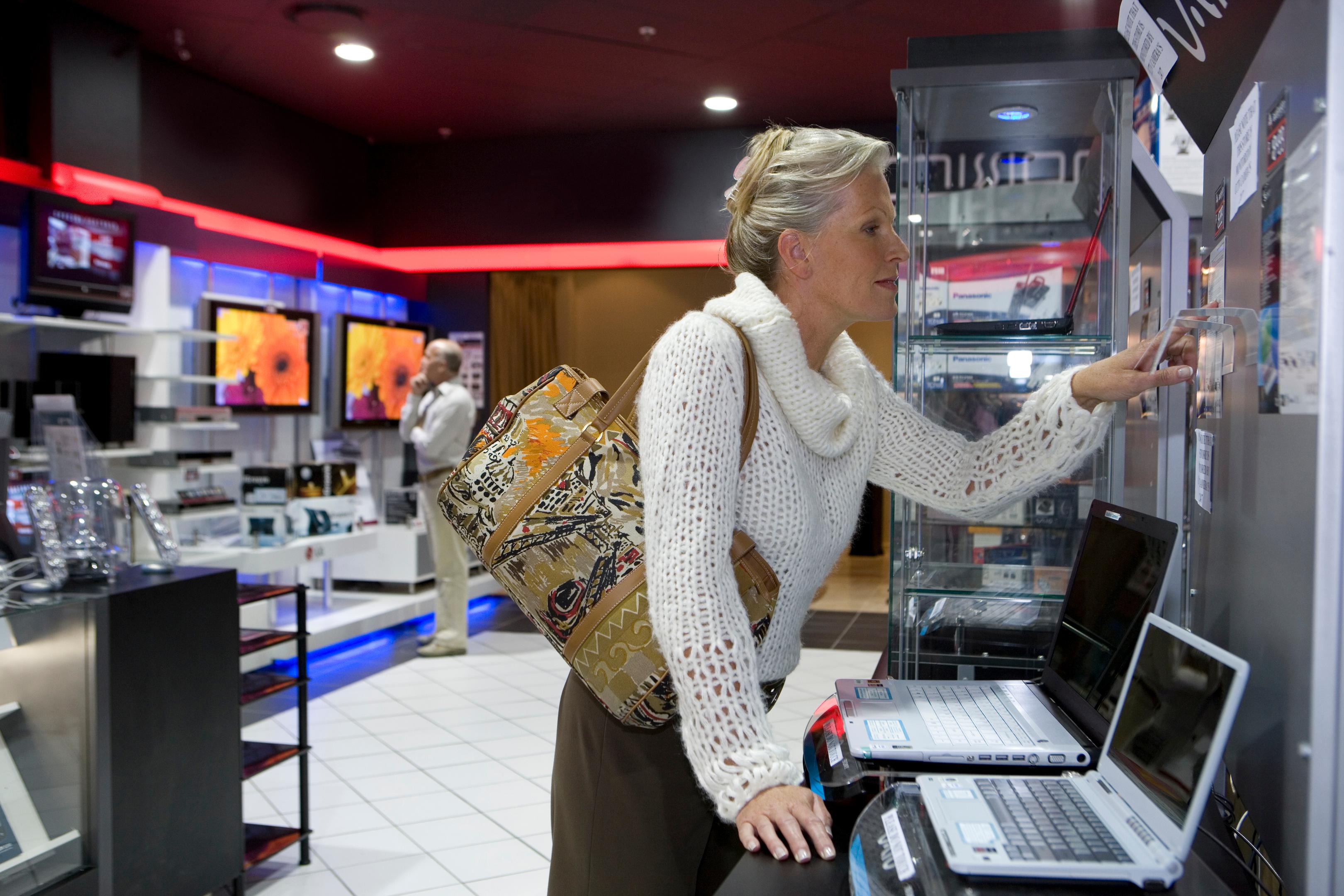 Femme faisant ses courses dans un magasin d'électricité pour ordinateur portable