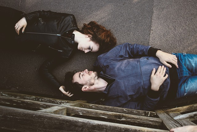 two people laying in the ground in opposite directions looking into each others eyes 