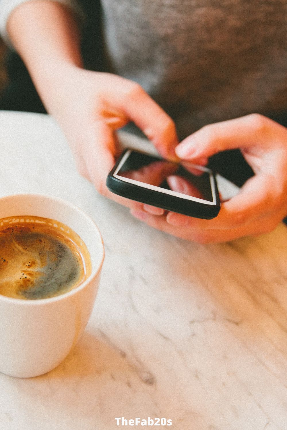 Woman texting wwth coffee next to her - What are the signs a guy is losing interest through text 