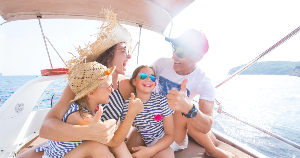 Happy family on a boat giving thumbs up while enjoying a day on the water near bayfront vacation rentals.