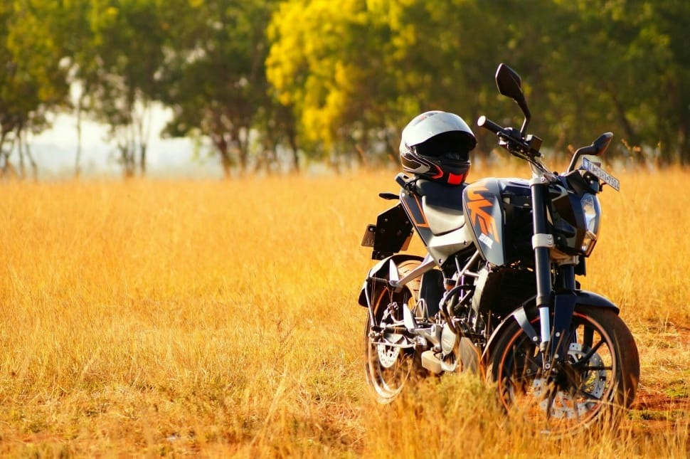 black naked sports motorcycle parked at grass field