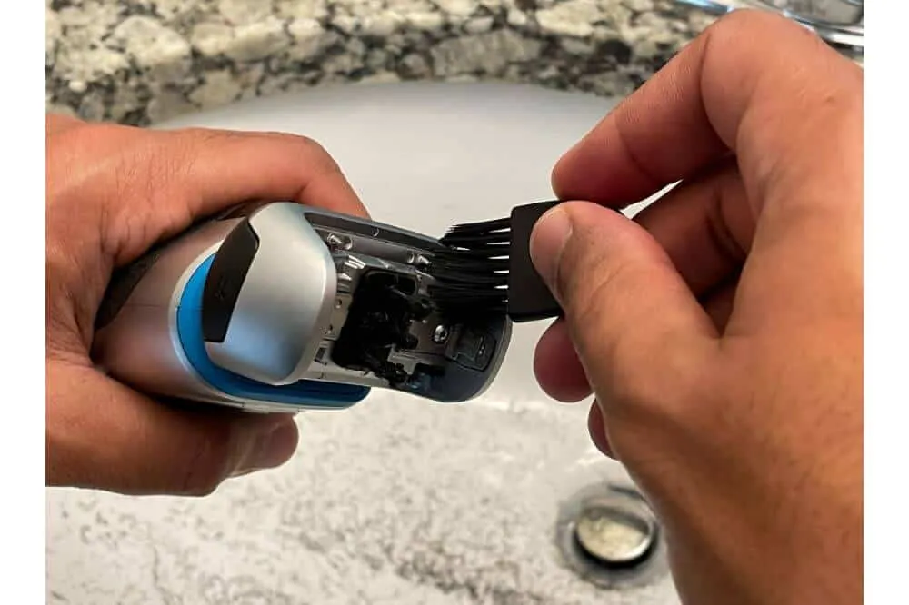 A person using a light machine oil and shaving foam to clean a braun shaver