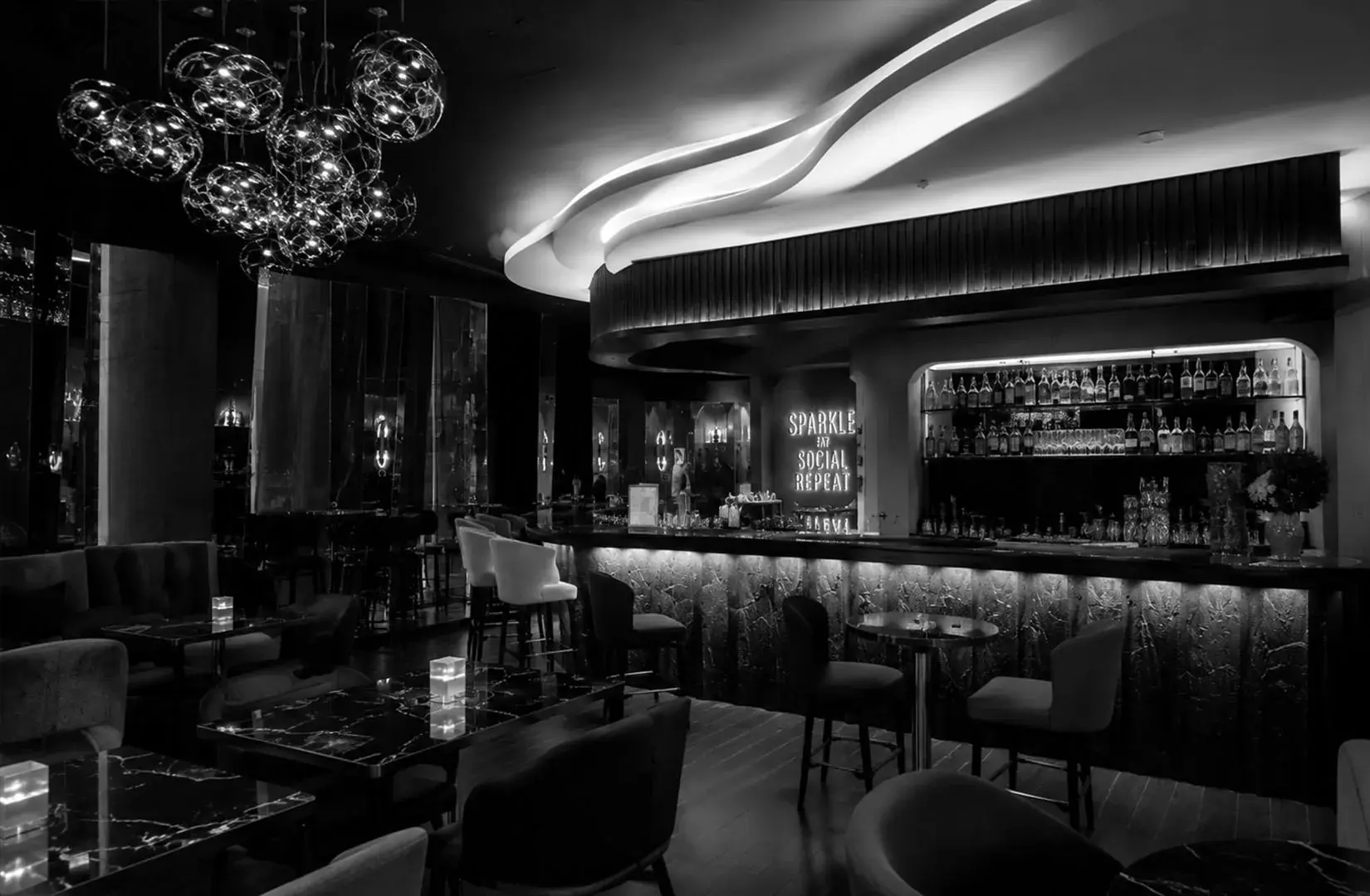 Stylish interior of Kaarla Wood-Fire Grill & Bar featuring a modern bar, elegant lighting, and cozy lounge seating.