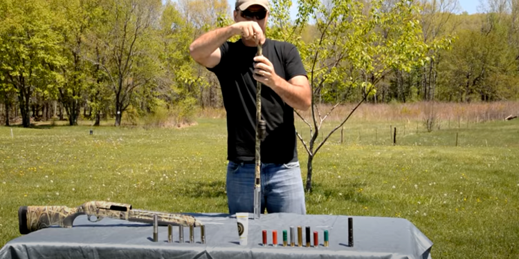 man in black shirt installing choke on gun 