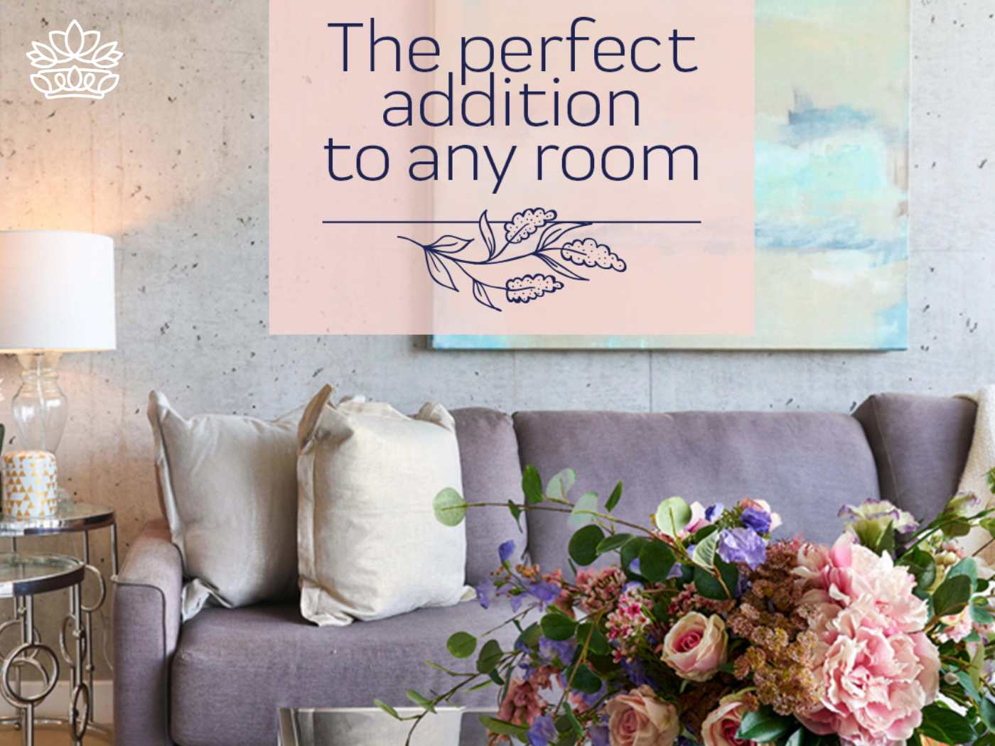 Cozy interior setting with a plush sofa and decorative cushions, complemented by a vibrant bouquet of artificial flowers, creating a homely atmosphere. Text overlay reads 'The perfect addition to any room', encapsulating the essence of home decor by Fabulous Flowers and Gifts.