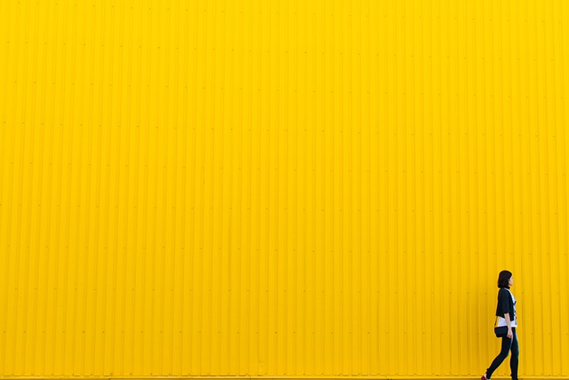 woman walking in front of yellow wall symbolizing the benefits of walk storming