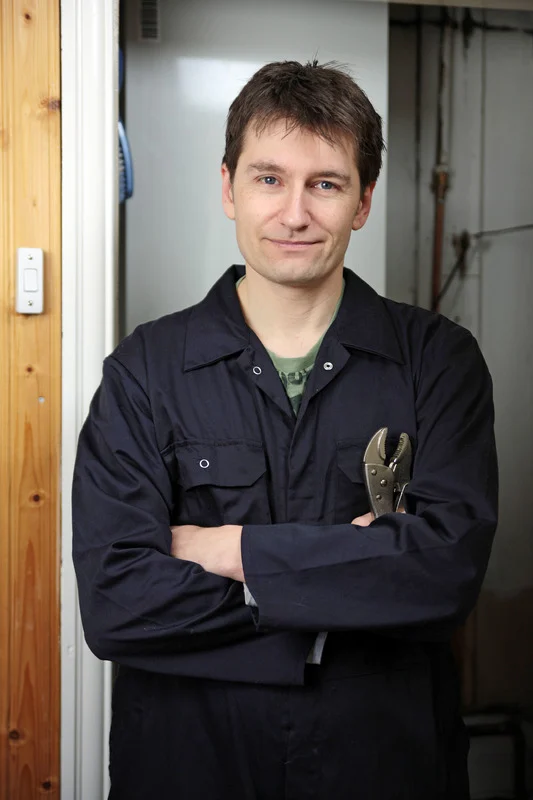 Ein Fachmann mit Werkzeug in der Hand steht bereit für Wartungs- und Reparaturarbeiten in einem Heizungsraum