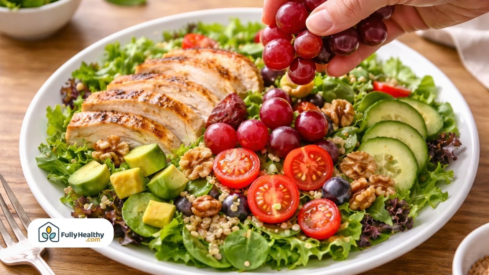 Grilled chicken salad topped with red grapes and fresh vegetables