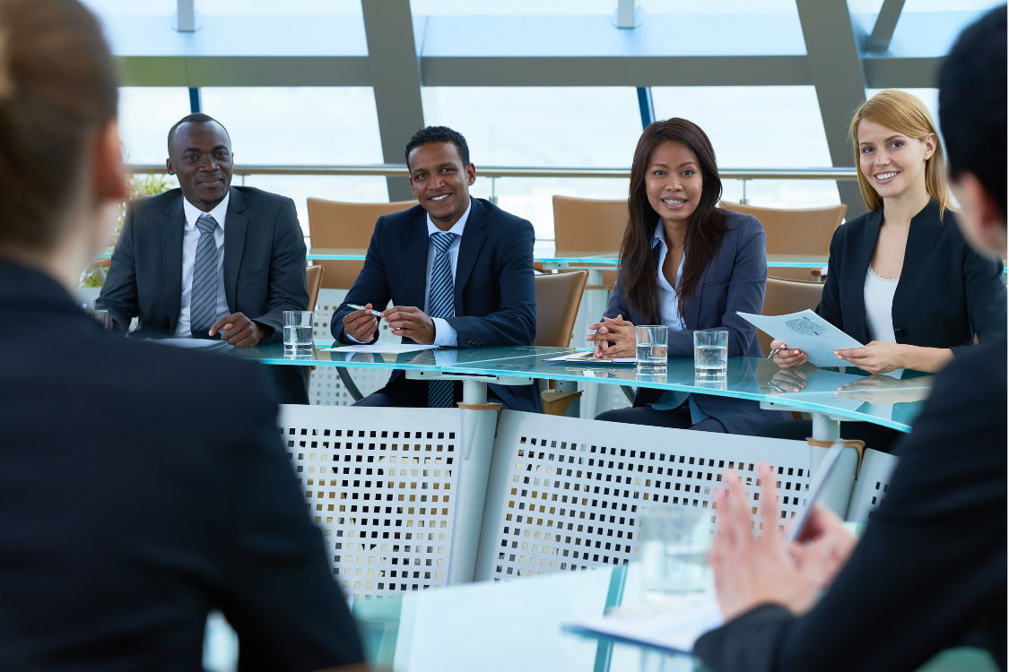 Business professionals sitting at a panel during a broker association event