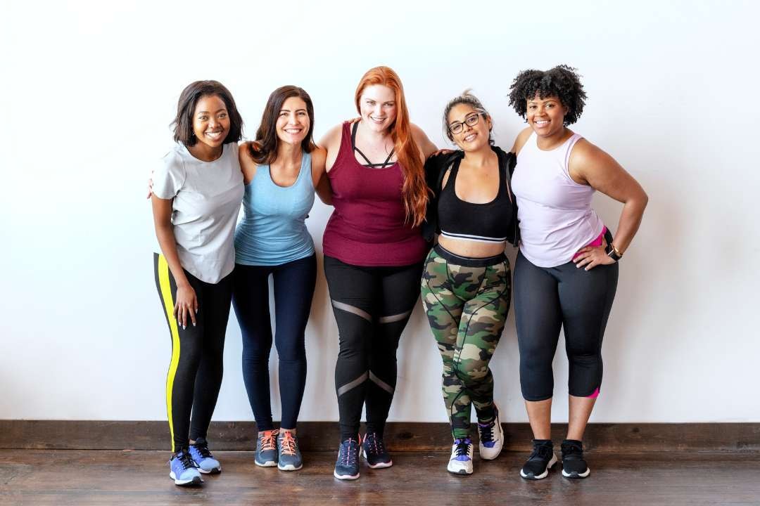 Five women in activewear standing and smiling, emphasising the role of supplements and a healthy immune system.