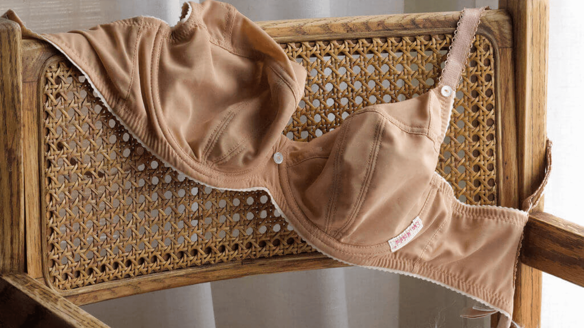 Ewa Michalak Polish full-bust bra with seamed cups and supportive band displayed on a woven chair