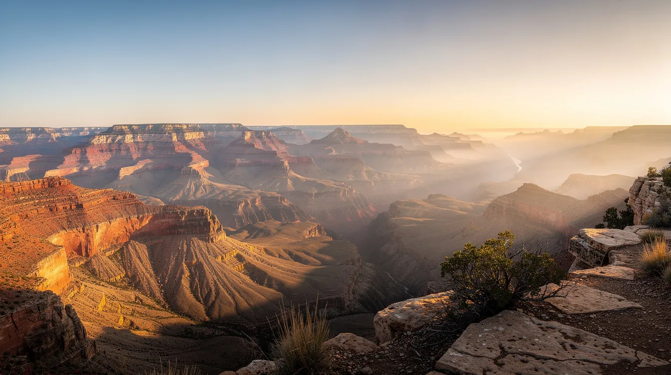 A breathtaking panoramic view of the Grand Canyon at sunrise, where golden light highlights the layered red rock formations. This stunning scene captures the essence of Grand Canyon National Park, showcasing the majestic canyon rim and inviting visitors to explore the many hotel options and outdoor activities available nearby.