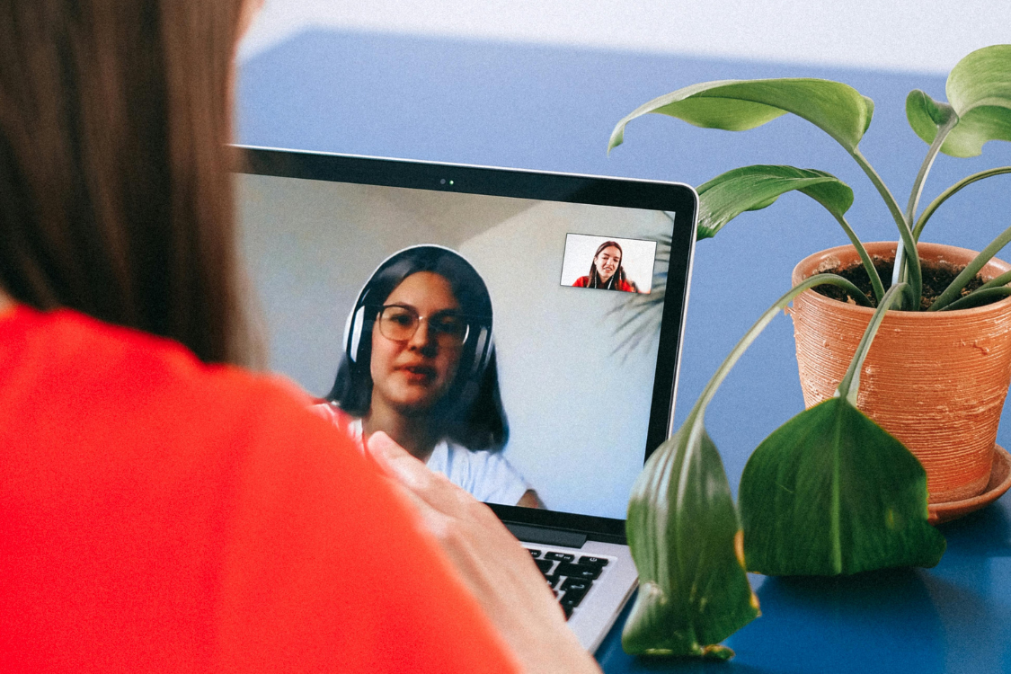 A remote job interview between a U.S. employer and a Filipino candidate conducted via video call on a laptop screen