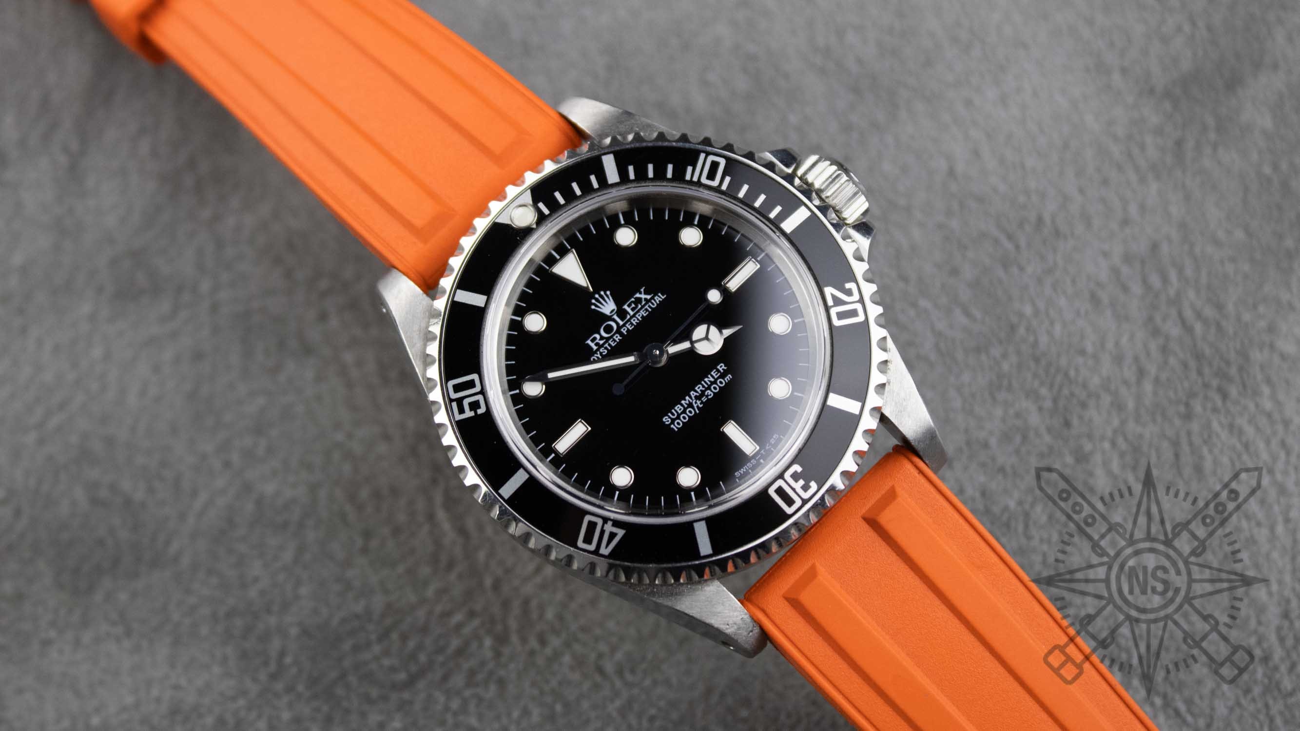A vibrant orange rubber watch strap displayed on a watch.